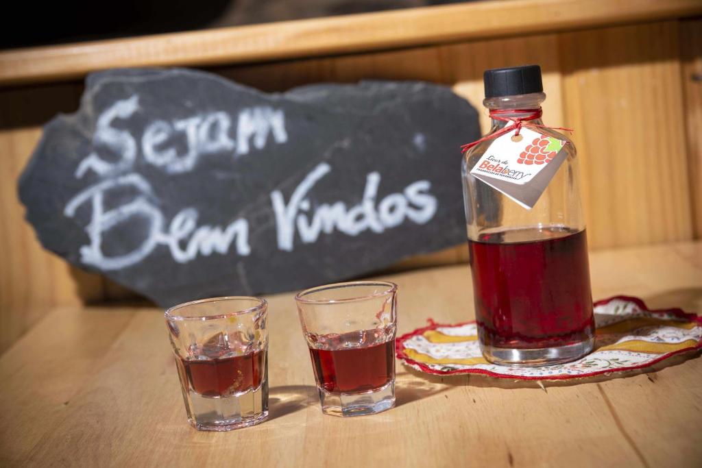 a bottle of drink and two glasses on a table at Moinho do Maneio in Penamacor