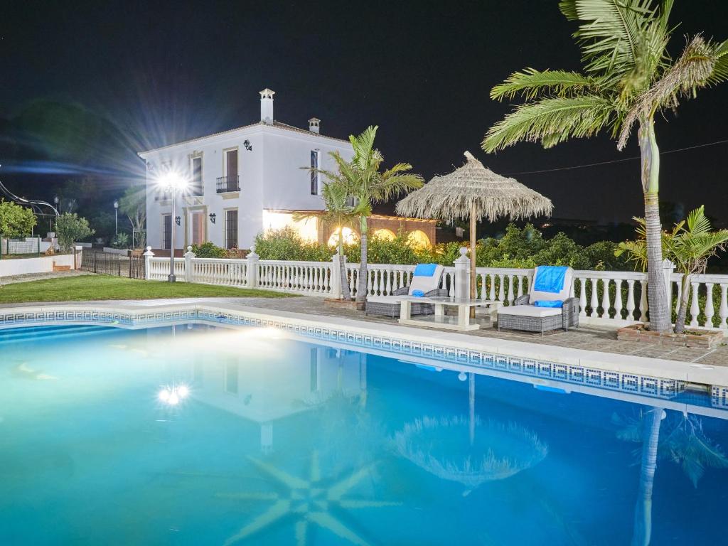 - une piscine en face d'une maison la nuit dans l'établissement Cubo's Villa Huerta de las Rosas, à Alhaurín el Grande