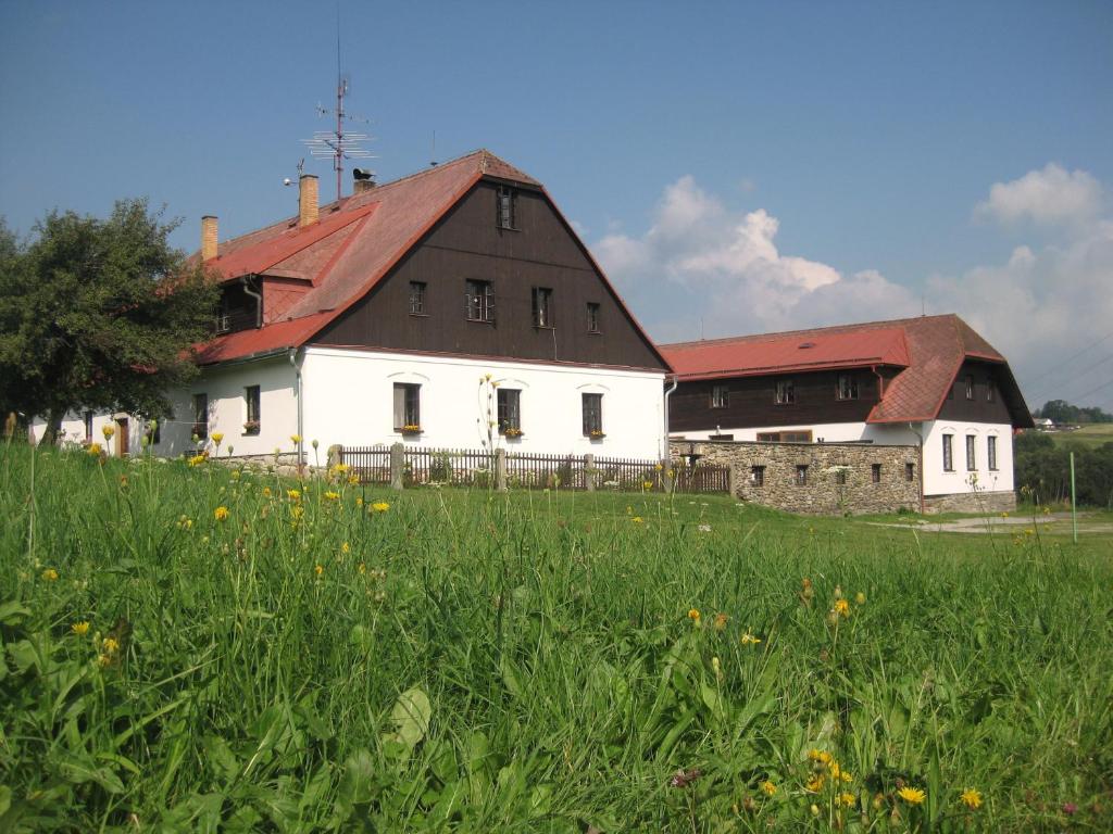 um grande edifício branco com um telhado vermelho num campo em Baurů Dvůr em Zdíkov