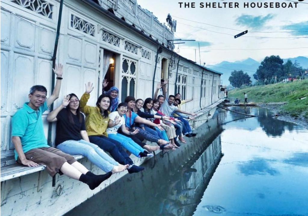 a group of people sitting on the side of a train at The Shelter Group of Houseboats & Tour organiser in Srinagar