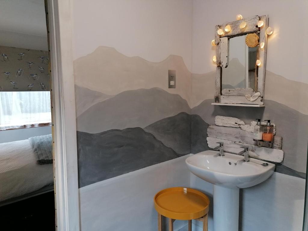 ein Bad mit einem Waschbecken und einem Spiegel in der Unterkunft Blas Rooms in Dunvegan
