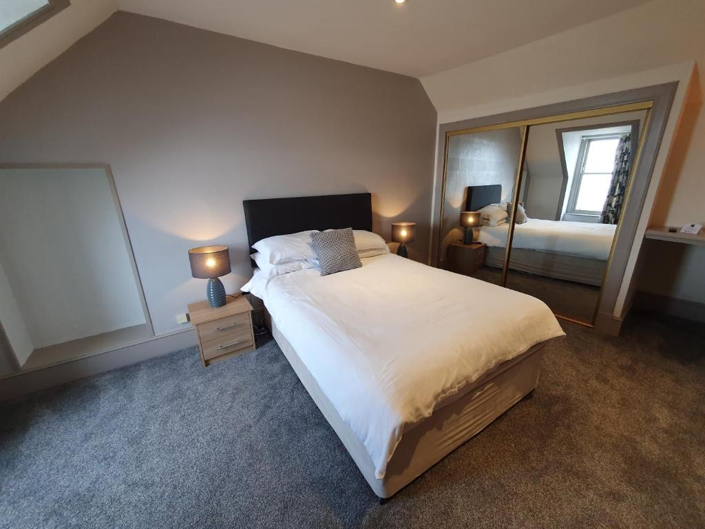 sypialnia z dużym łóżkiem i lustrem w obiekcie House by the Harbour - NC500 Route w mieście Wick