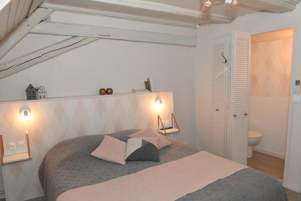 a bedroom with a large bed with two pillows at Chambres d&#39;hôtes Chez Caroline in Colmar