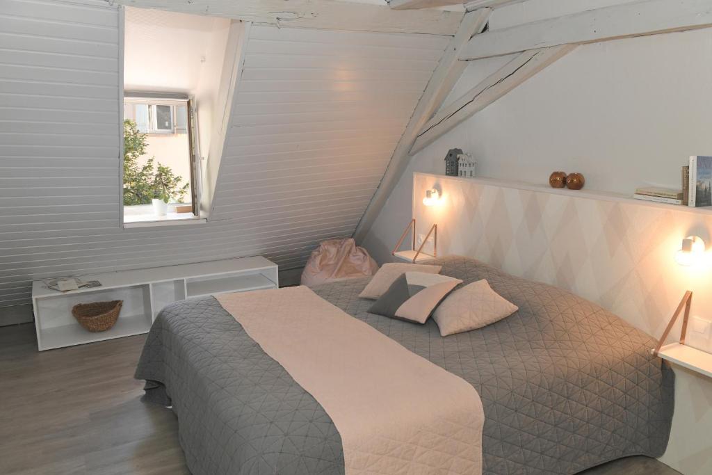 a bedroom with a large bed with two pillows at Chambres d&#39;hôtes Chez Caroline in Colmar