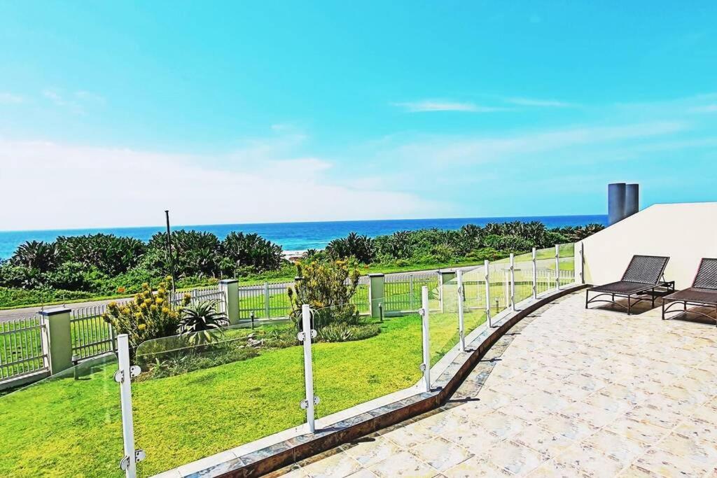 un patio con sillas y el océano en el fondo en Uvongo - Beach Paradise & Open Ocean View, en Uvongo Beach