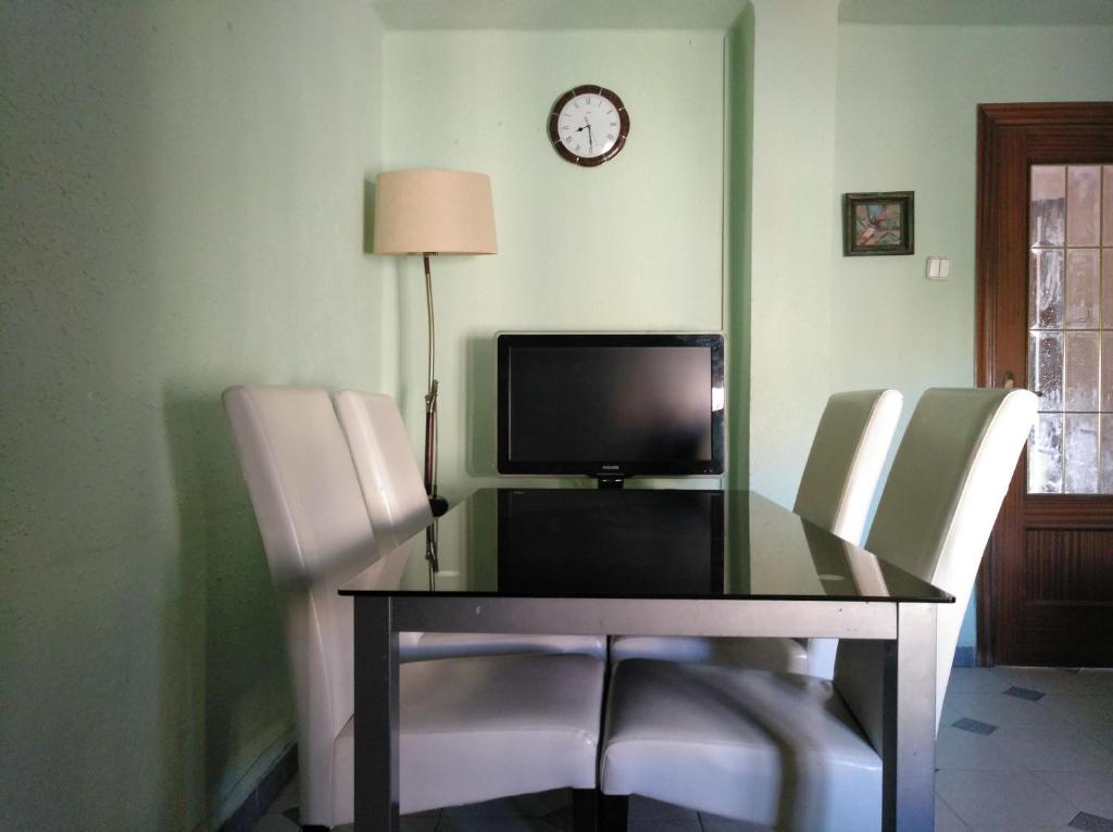 mesa de comedor con TV y 2 sillas en Private Apartment Horticultor Bosch, en Valencia