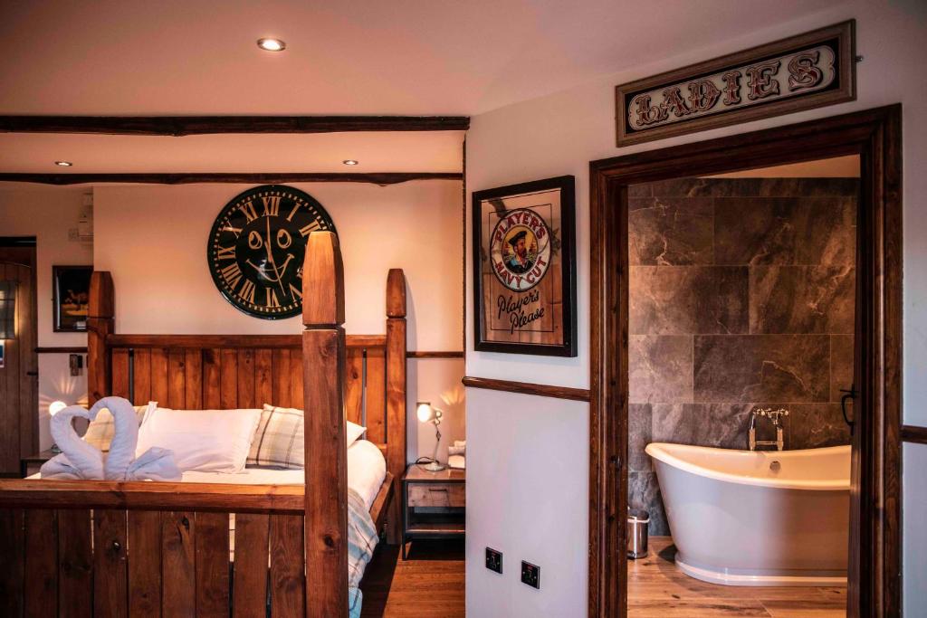 a room with a bed, a mirror, and a painting on the wall at South Causey Inn in Stanley