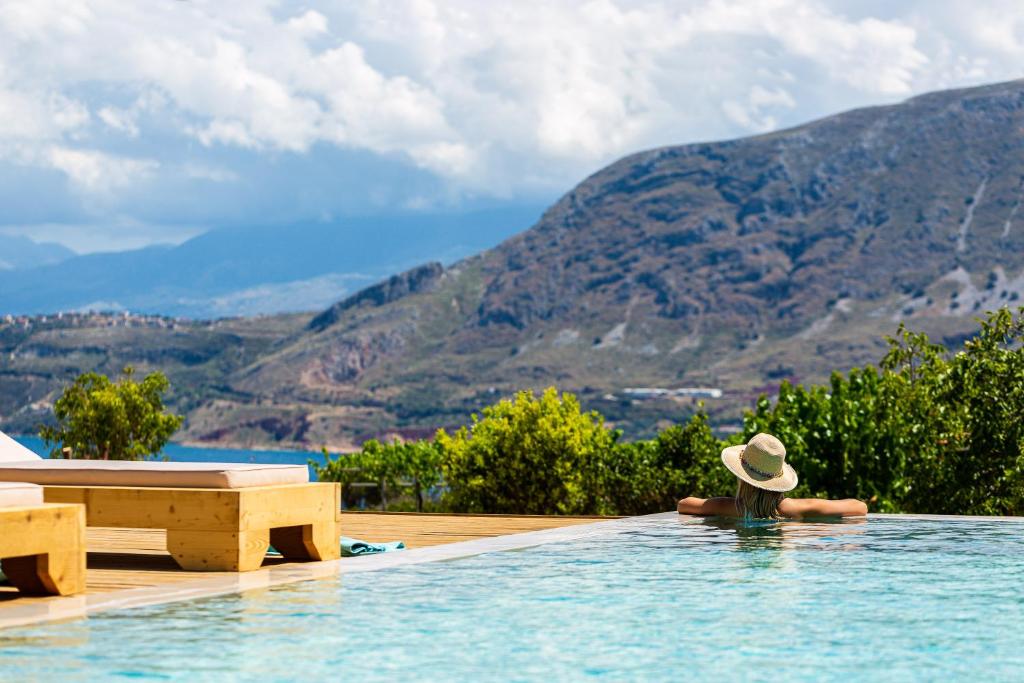 una persona en una piscina con sombrero en Artemisia Residence, en La Canea