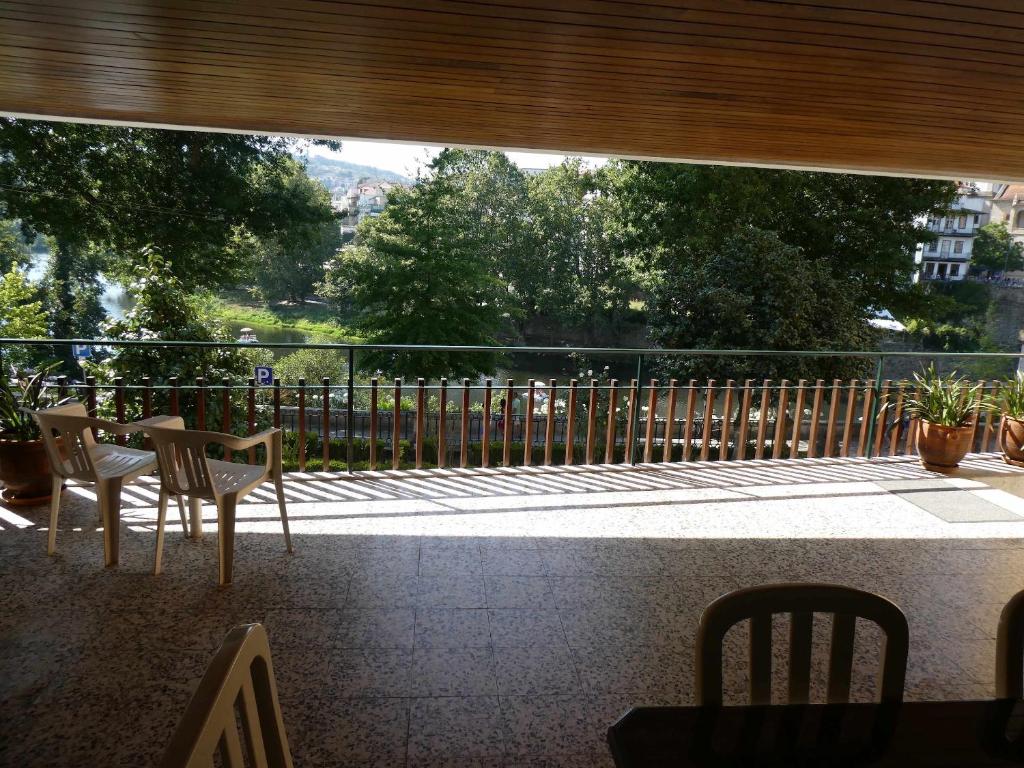 uma varanda com uma mesa e cadeiras e uma cerca em Casa do Ribeirinho em Amarante