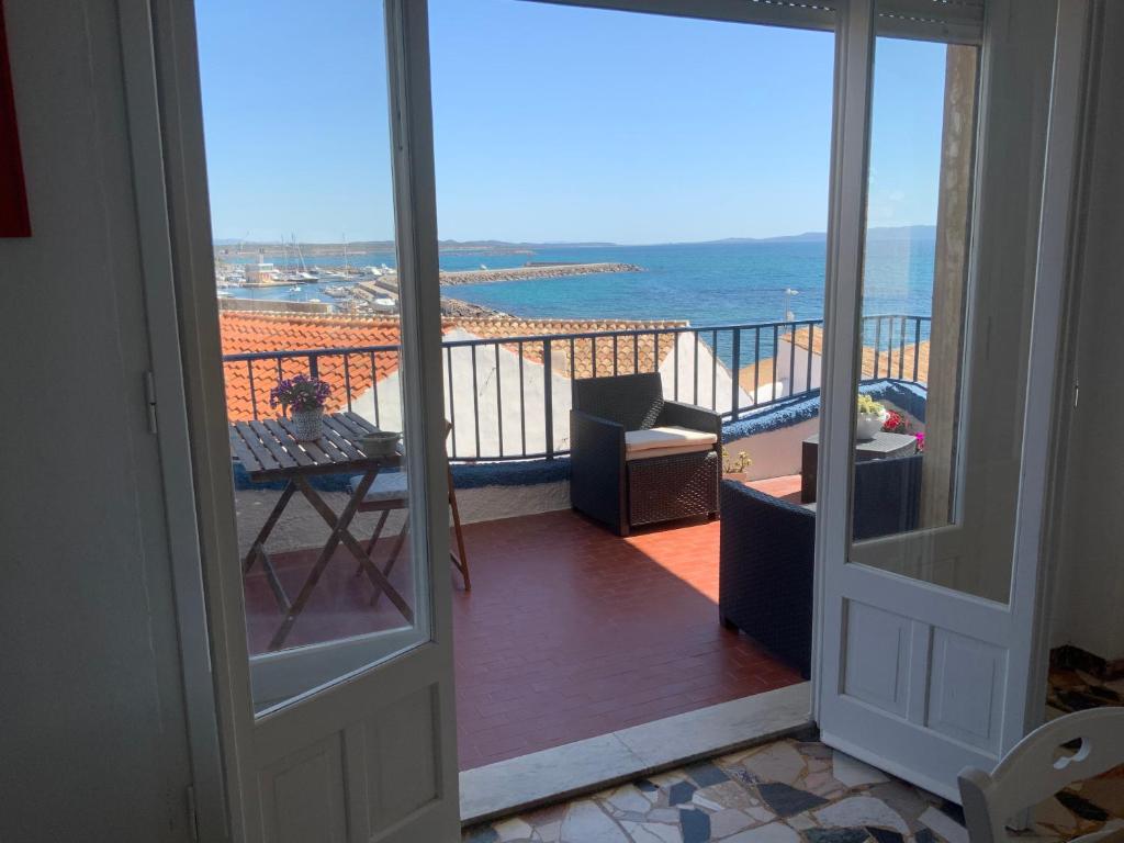 uma porta para uma varanda com vista para o oceano em Sa Caletta Appartamenti em Portoscuso