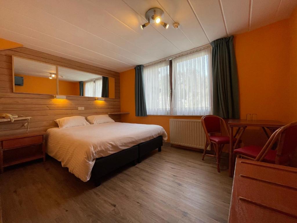 Un pat sau paturi într-o cameră la Hotel Les Arcades
