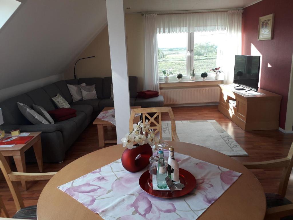 sala de estar con mesa y sofá en Ferienwohnung Am Damm en Wesel