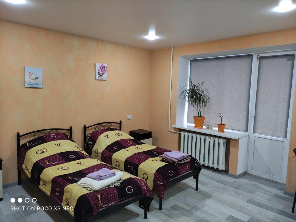 Duas camas num quarto com uma janela em Квартира студіо біля Автовокзалу em Kremenchuk