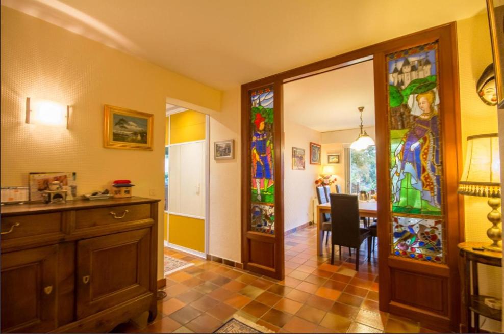 a kitchen with a dining room with stained glass windows at La Vie Au Roze in Quéven
