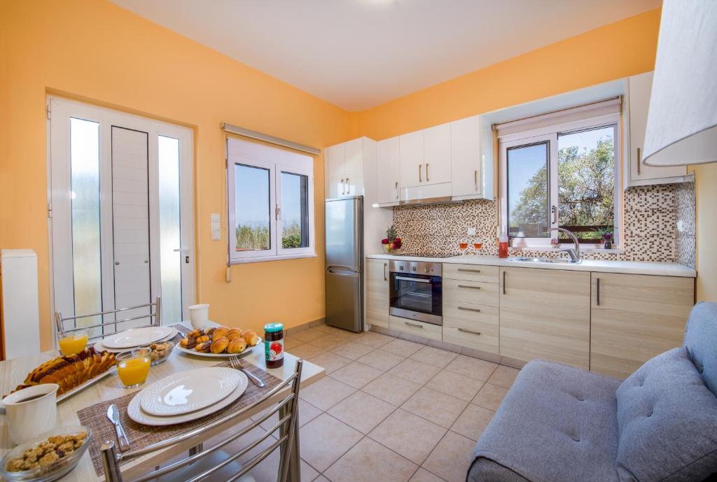 a kitchen with yellow walls and a table with food on it at Georgia' s Apartment No1 in Maleme