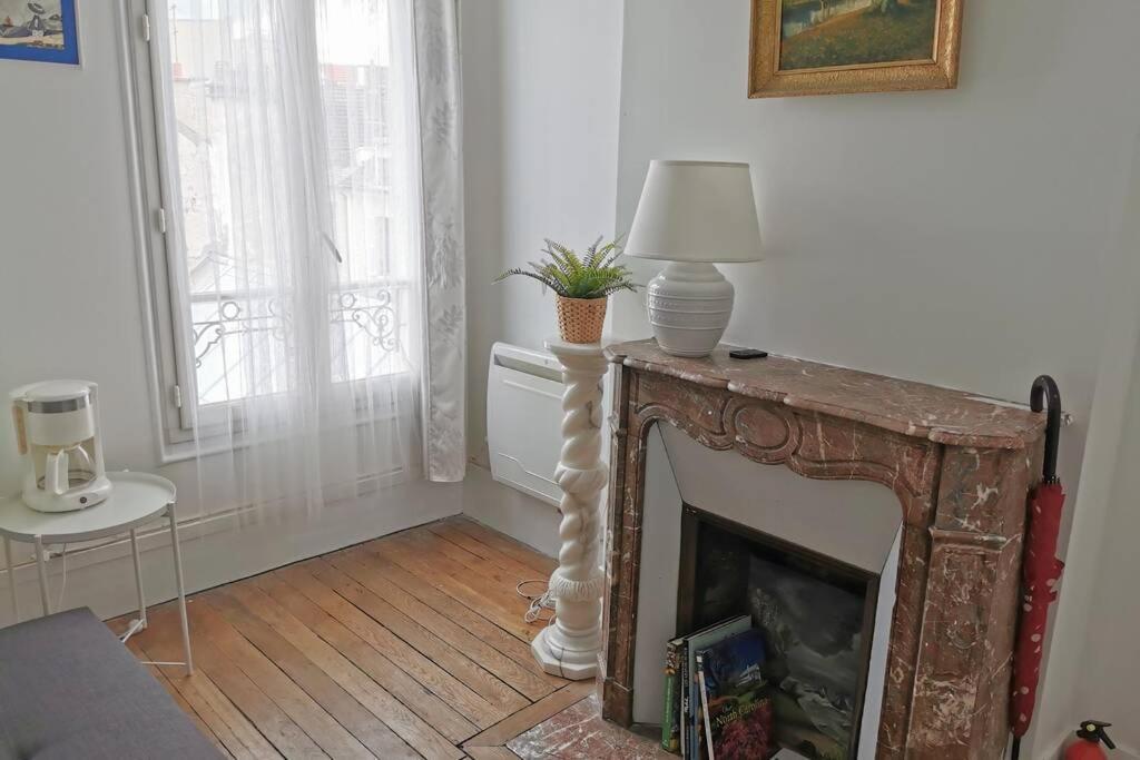 un salon avec une cheminée et une lampe. dans l'établissement Wei&Pei Apartment - Hypter Center St Germain En Laye 1min RER, à Saint-Germain-en-Laye