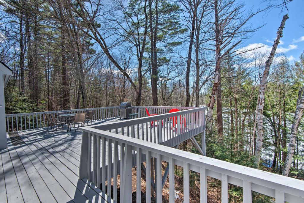 a wooden deck with a table and chairs on it at Wooded Waterfront Grantham Home Less Than 10 Mi to Ski! in Grantham