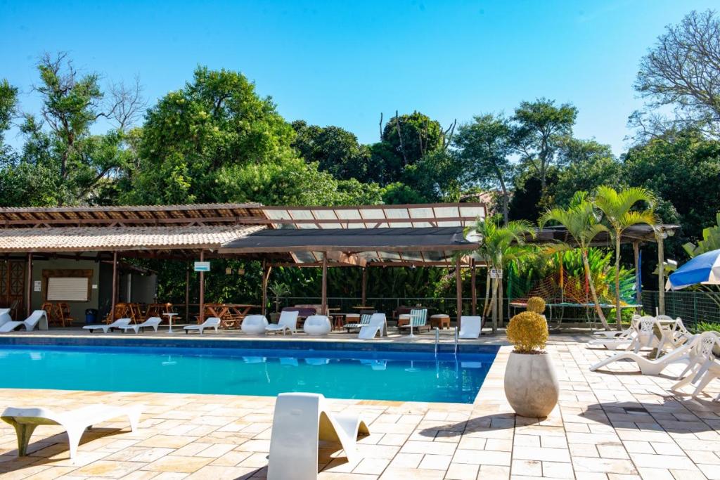 a swimming pool with lounge chairs and an umbrella at Hotel Santiago in Lindóia
