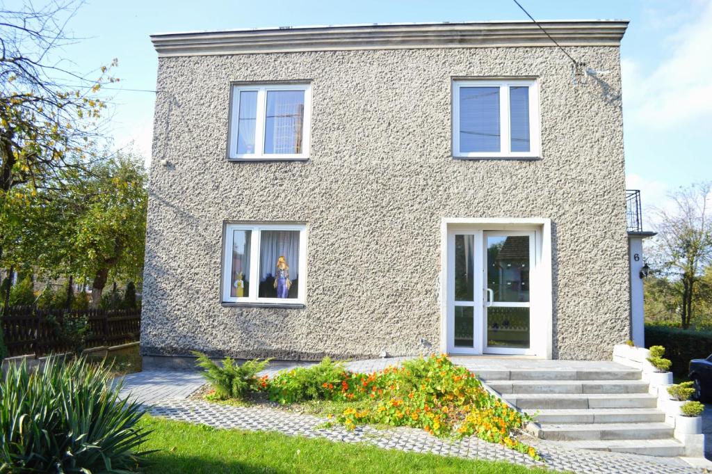 a brick house with white windows and flowers at Hotel Colibri in Zdzieszowice