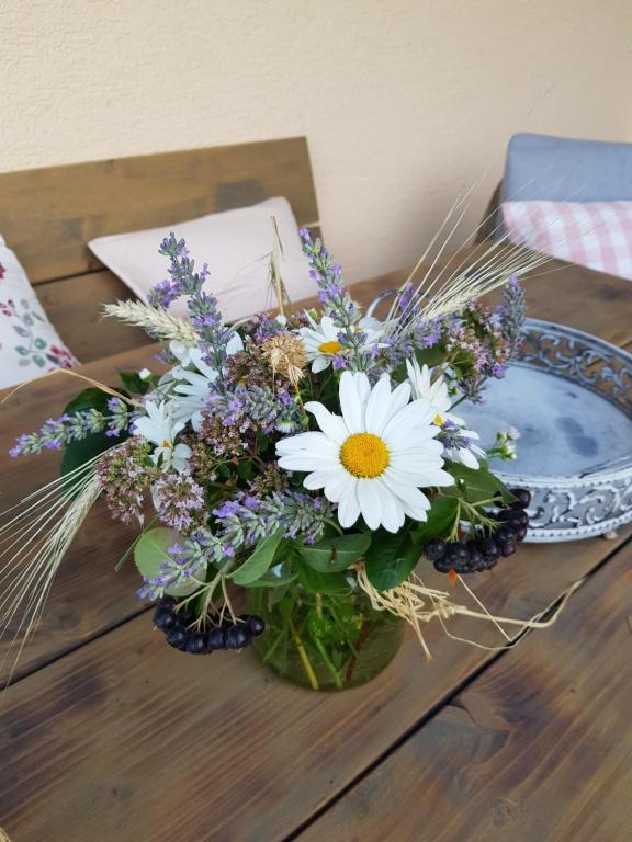 un ramo de flores en un jarrón sobre una mesa en Ferienwohnung Kraichgaublick en Angelbachtal