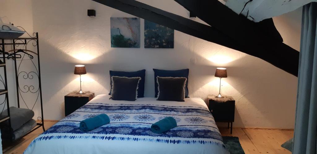 a bedroom with a large bed with blue pillows at Les Gabelous - micro-gîtes - Viroinval in Dourbes
