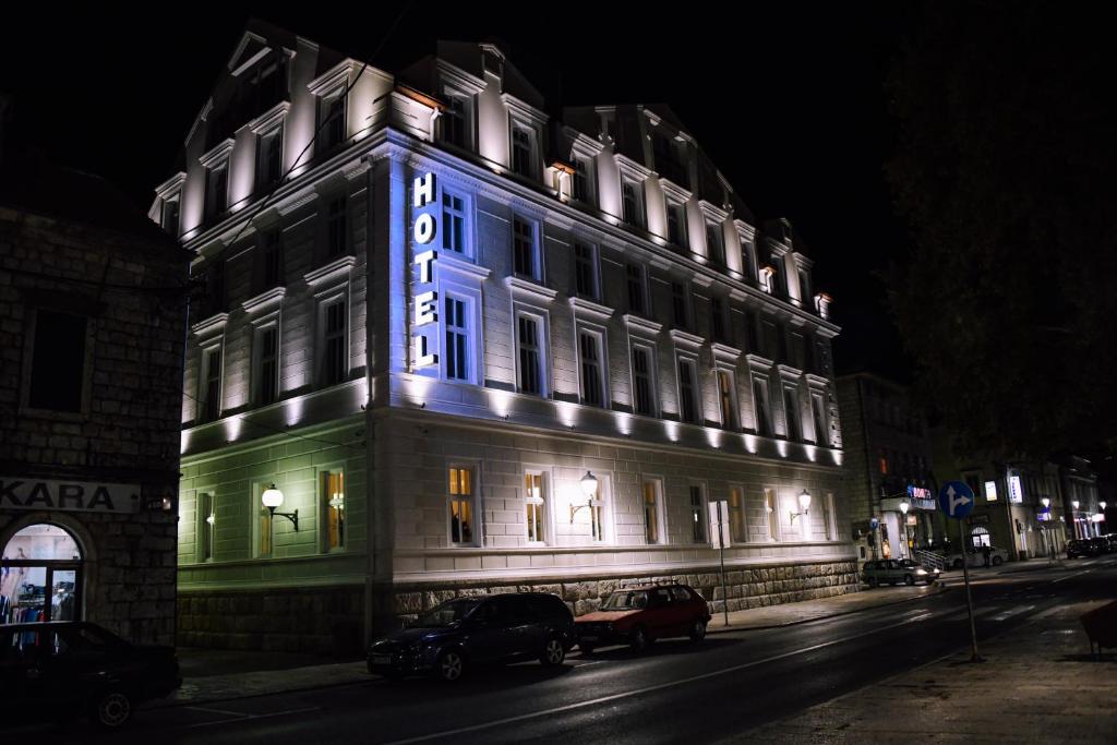 a building with a blue lit up sign on it at Hotel Central Park in Trebinje
