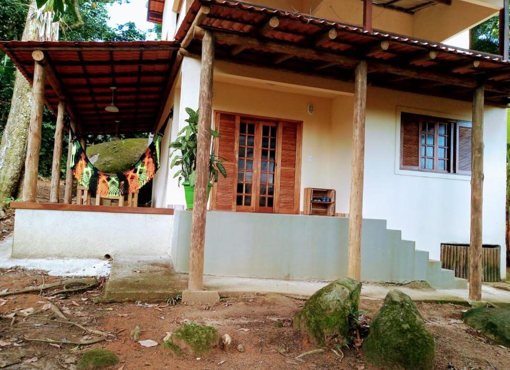 a white house with a porch and a porch at Vivenda Cravo&Canela in Abraão