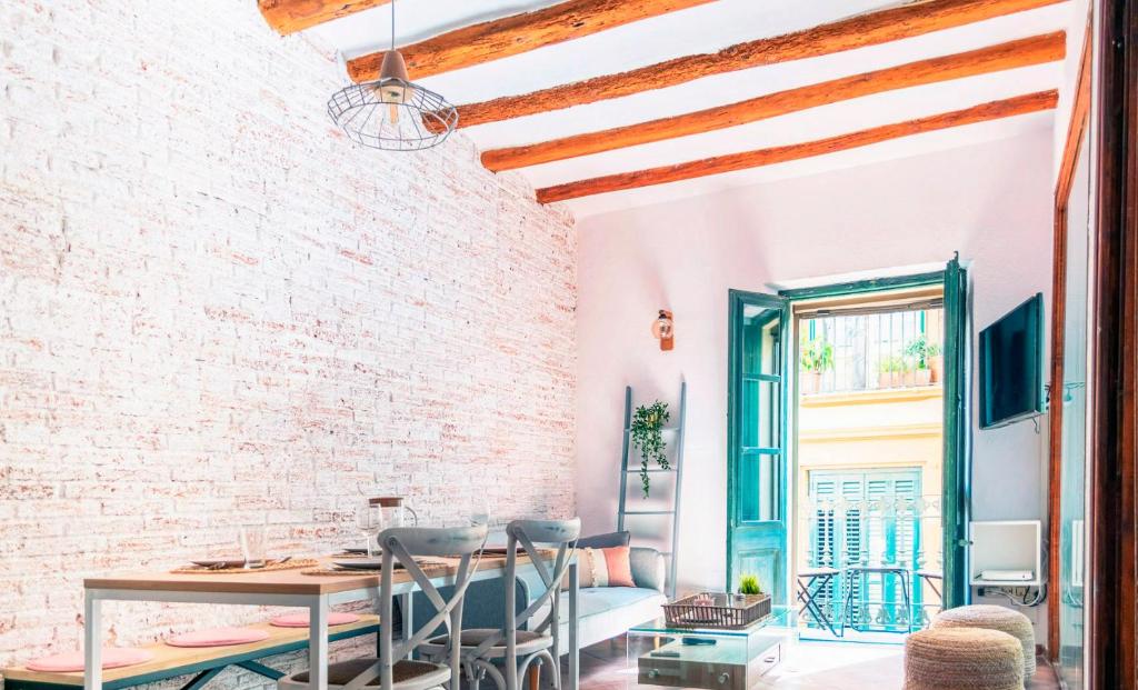 a dining room with a brick wall and a table and chairs at Apartamento acogedor y exclusivo de Eva in Sant Feliu de Guíxols