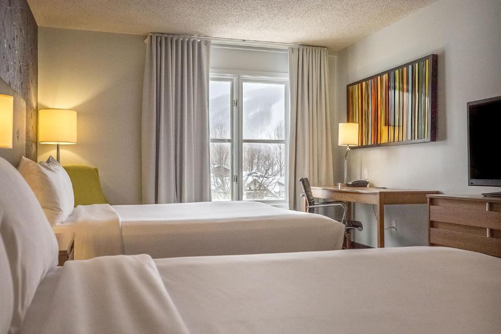 Postel nebo postele na pokoji v ubytování Hotel Chateau Bromont