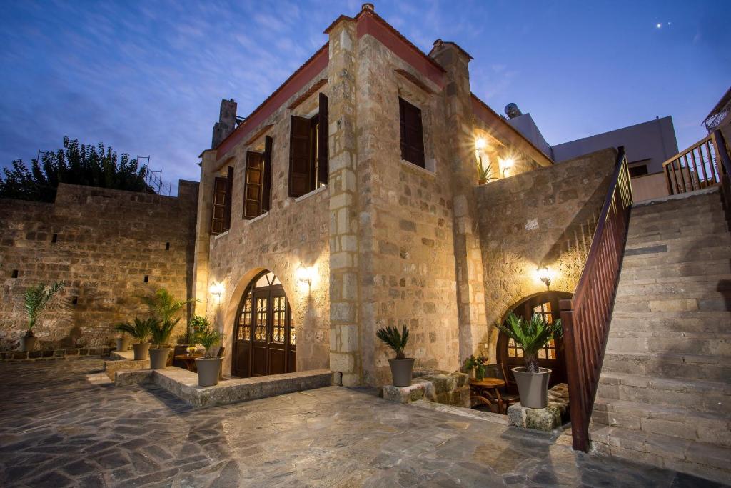 a stone building with a courtyard with potted plants at Kamara Antica Apartments in Rhodes Town