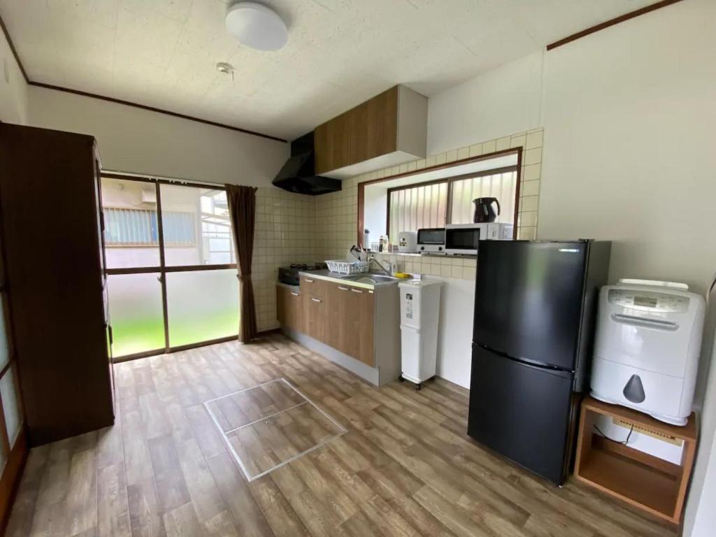 a kitchen with a black refrigerator in a room at Trust Maison Hakone Sengokuhara - Vacation STAY 24226v in Sengokuhara