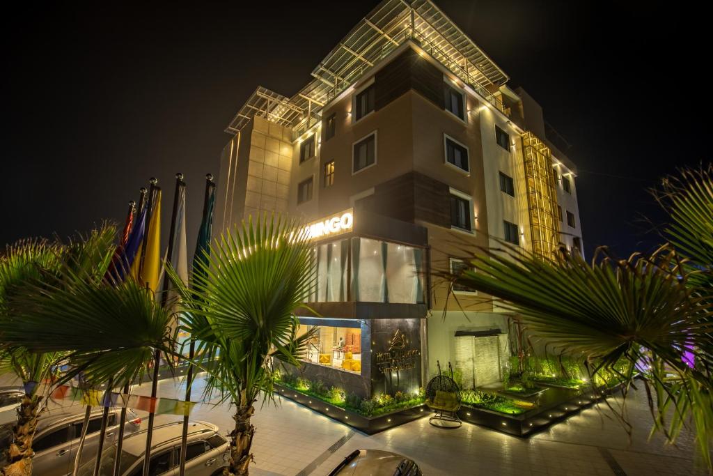 a tall building with palm trees in front of it at Hotel Da Flamingo in Butwāl