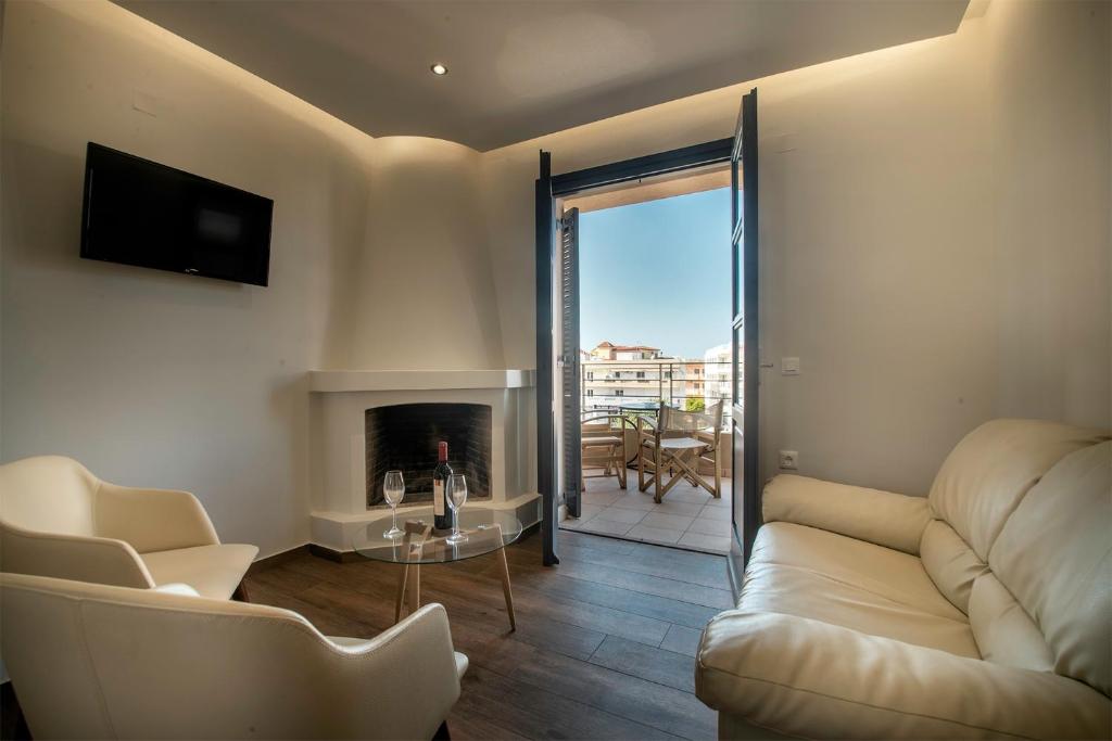 a living room with a couch and a fireplace at Villa Margarita Suites in Hersonissos