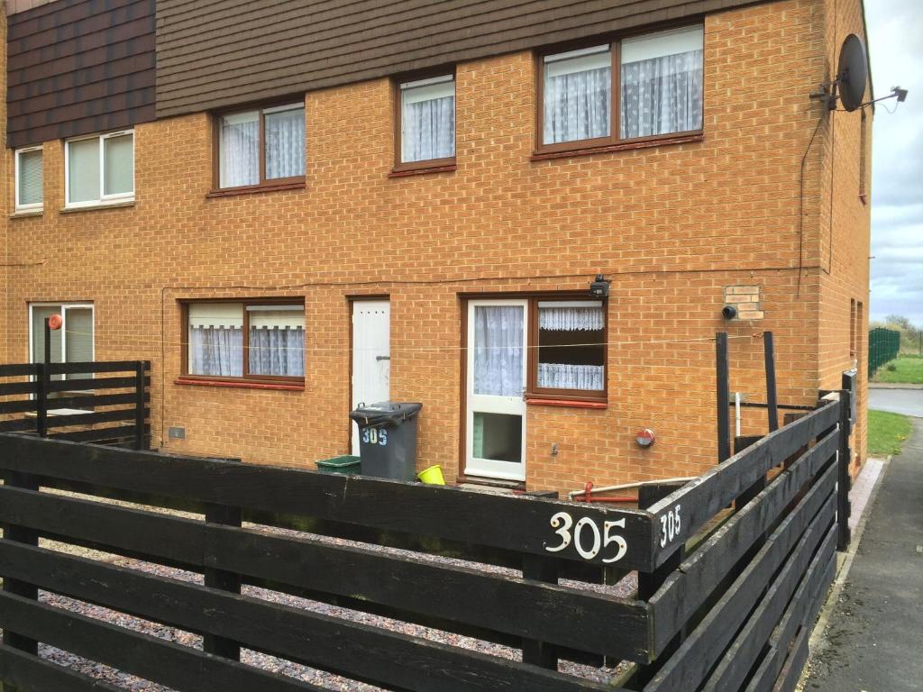 a brick house with a black fence in front of it at Morrison Close in Newton Aycliffe