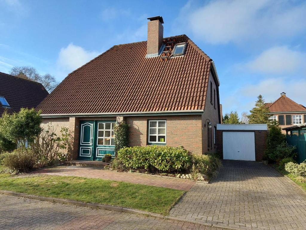 uma casa de tijolos com telhado castanho em Ferienhaus Blaue Nordseewelle em Esens