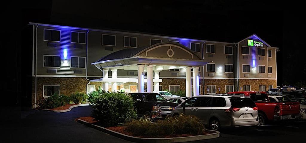 un hotel con coches aparcados frente a un aparcamiento en Holiday Inn Express - Ludlow - Chicopee Area, an IHG Hotel en Ludlow