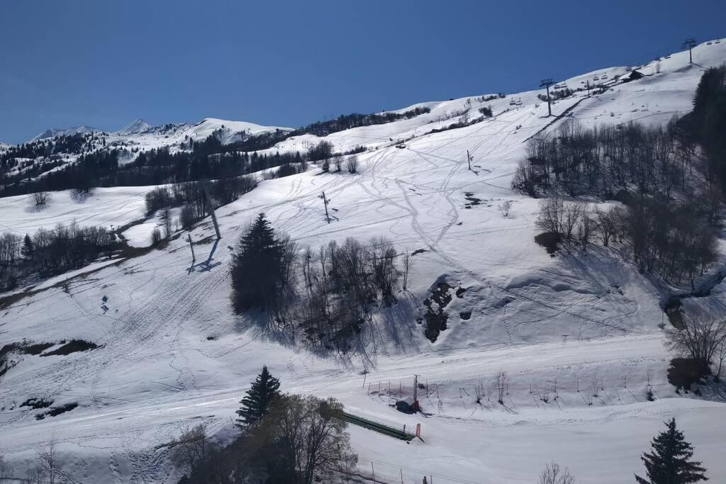 Studio 4pers vue piste في لي كوربيه: منحدر مغطى بالثلج مع أشخاص يتزلجون أسفل الجبل