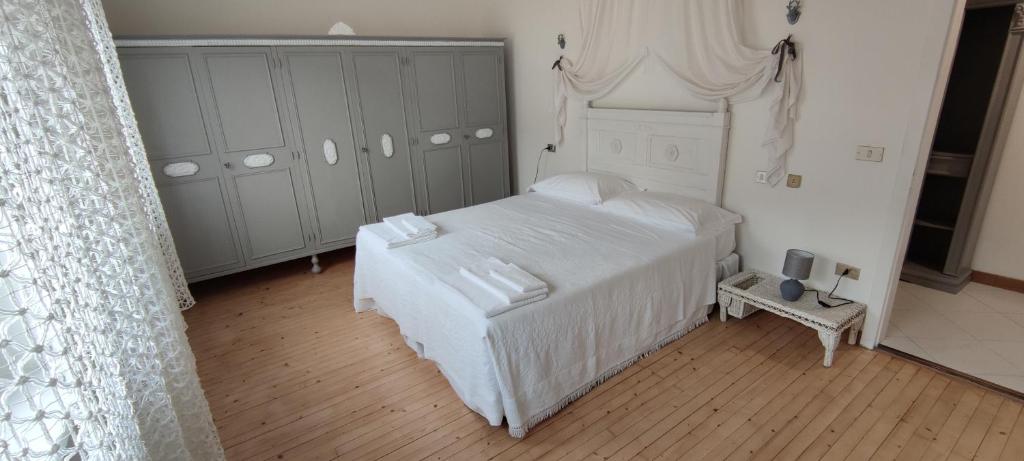 ein Schlafzimmer mit einem weißen Bett in einem Zimmer in der Unterkunft le Mongolfiere 2 in Malè