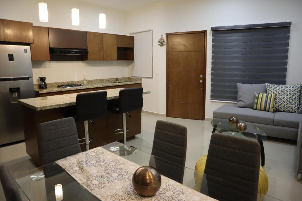 馬薩特蘭的住宿－Departamento nuevo a 3 min de la playa，厨房以及带沙发和桌子的客厅。
