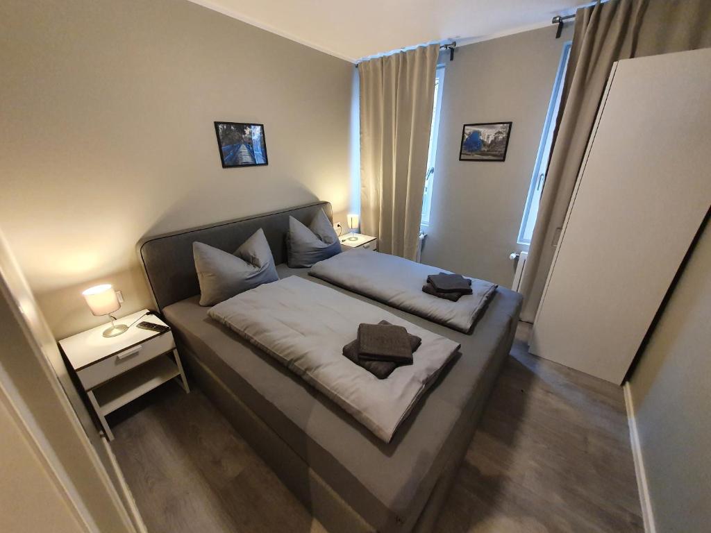 ein kleines Schlafzimmer mit einem Bett in einem Zimmer in der Unterkunft Stadt Apartments Solingen in Solingen