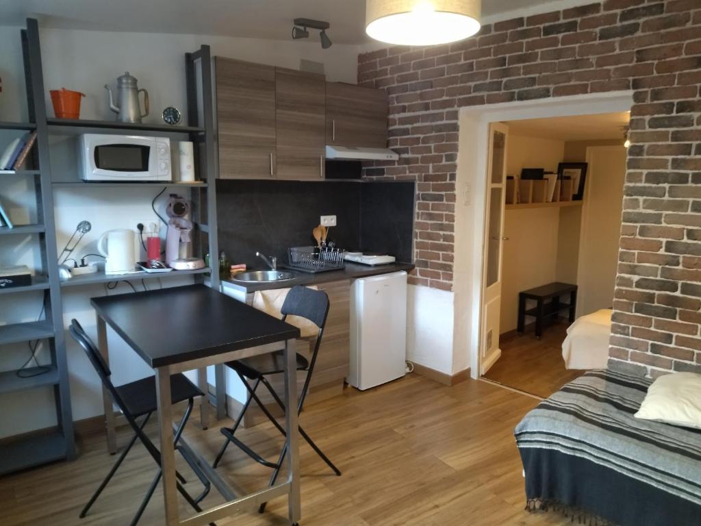 uma pequena cozinha e sala de estar com mesa num quarto em Aurillac meuble de tourisme em Aurillac