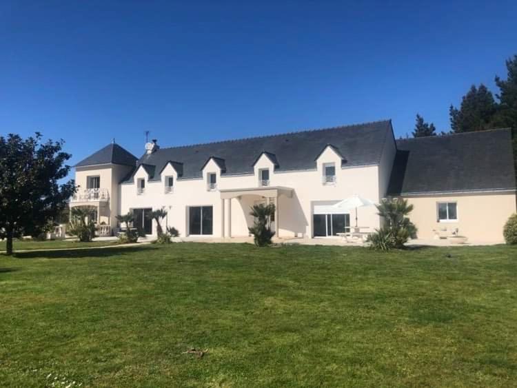 una gran casa blanca con un gran patio en LA COTTINIERE, en Drefféac