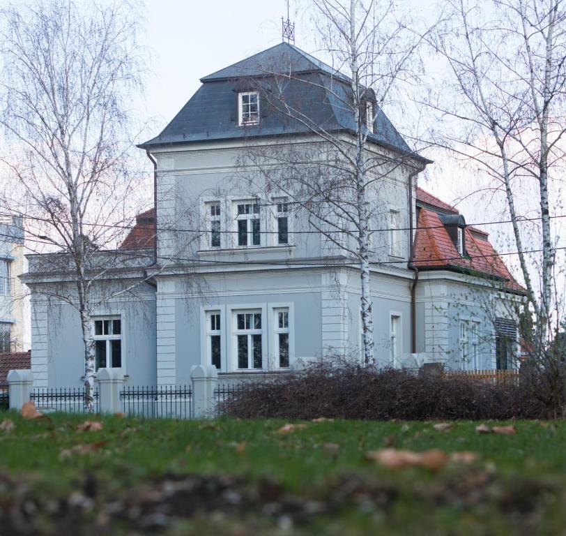 una gran casa blanca con techo de gambrel en Villa Ljiljana en Vinkovci