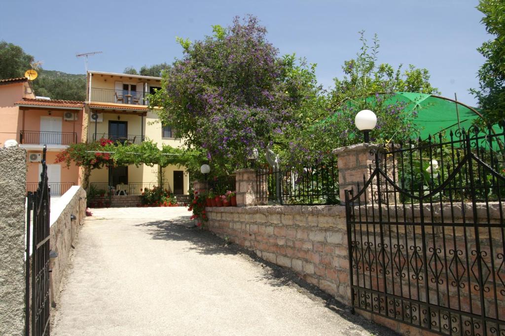 una valla frente a una casa con un edificio en Kefalas Apartments, en Parga