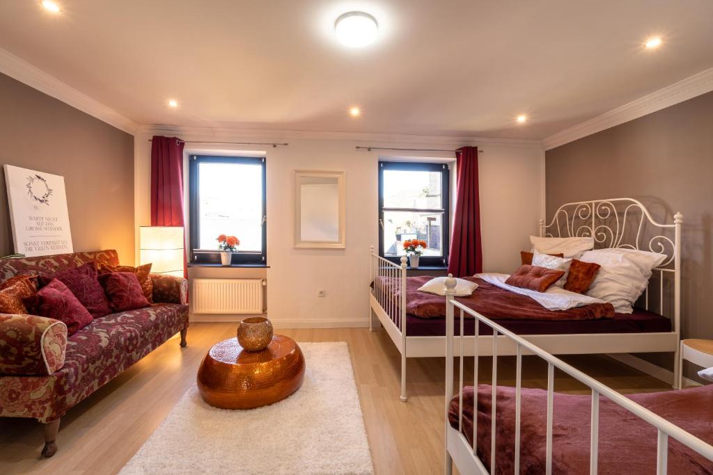 1 dormitorio con 2 literas y sofá en Green Valley Lounge Apartment, en Weibern