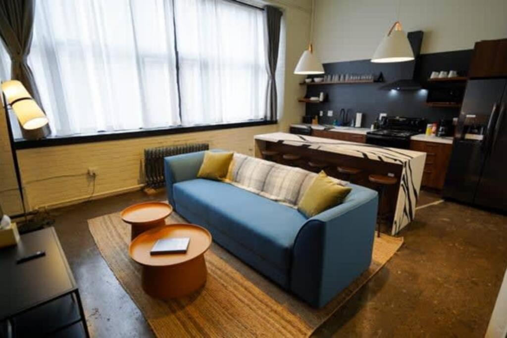 a living room with a blue couch and a table at 3E - *Renovated* 3 min to Hillman Cancer Center Sleeps 6 in Pittsburgh