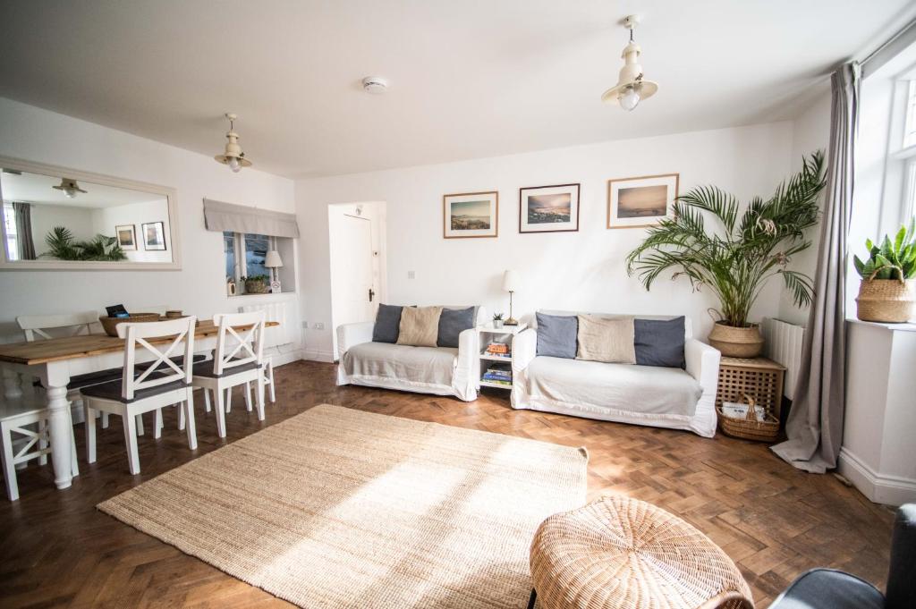 ein Wohnzimmer mit weißen Möbeln und einem Tisch in der Unterkunft Flat 1 Teneriffe in Lyme Regis