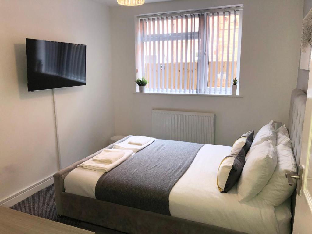 a bedroom with a bed and a flat screen tv at Coastal Retreat - Skegness in Skegness