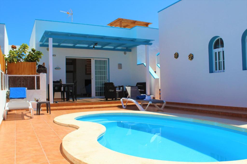 a swimming pool in the middle of a house at Villa Delhi by Privilege Bay in La Oliva