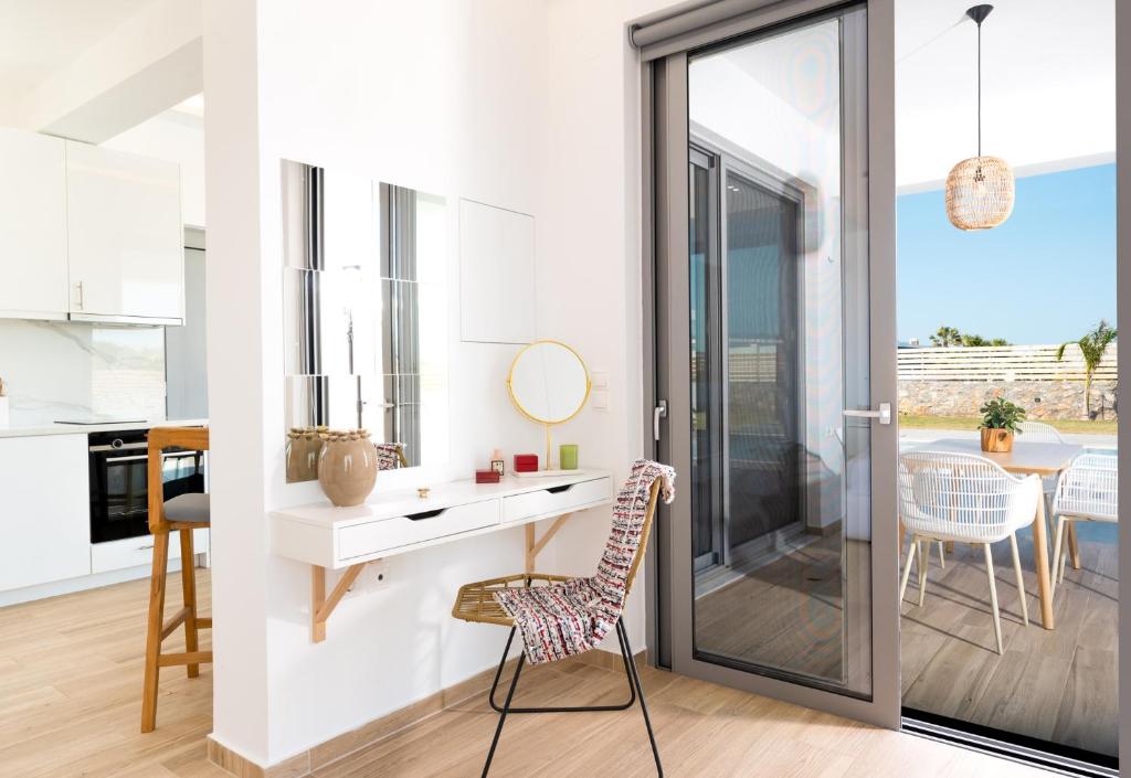 a kitchen and dining room with a desk and chair at Sardines Luxury Villas in Analipsi